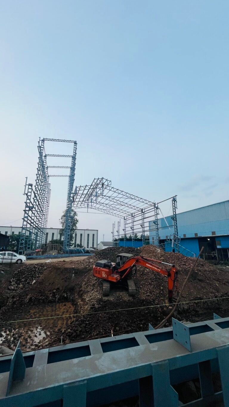 Lattice steel columns and roof trusses being erected